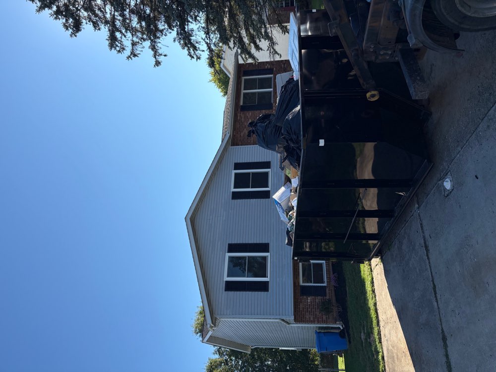 Loaded black roll-off dumpster at a residential cleanout